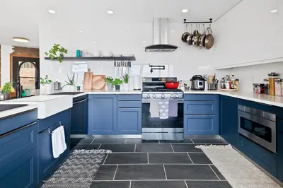 a blue kitchen with white walls and blue cabinets at 5 Star Gorgeous Cliffside Chalet with Panoramic Views in Tannersville