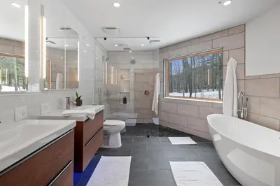 a bathroom with two sinks and a tub and a toilet at 5 Star Gorgeous Cliffside Chalet with Panoramic Views in Tannersville