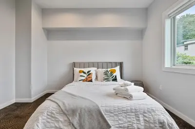 a bedroom with a bed with white walls and a window at Piermont Waterfront Villa with Hot Tub in Piermont