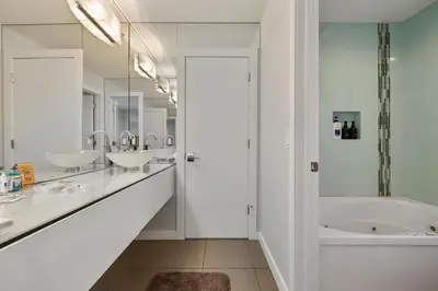 a white bathroom with three sinks and a tub at Piermont Waterfront Villa with Hot Tub in Piermont