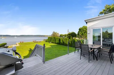 a wooden deck with a table and chairs on it at Piermont Waterfront Villa with Hot Tub in Piermont
