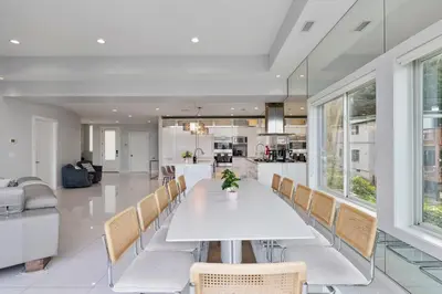 a dining room and kitchen with a white table and chairs at Piermont Waterfront Villa with Hot Tub in Piermont