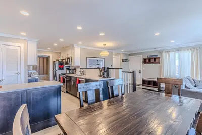 a kitchen with a wooden table and a dining room at Skylift Lodge - Luxury Mountain Creek family condo in Vernon Township