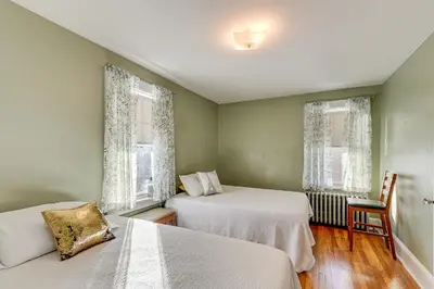 a bedroom with two beds and two windows at Charming Connecticut Retreat Near Museums and Hiking in Waterbury