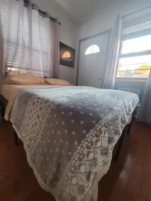 a bedroom with a bed with a blanket on it at New York in Woodside