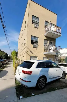 a white car parked in front of a building at New York in Woodside