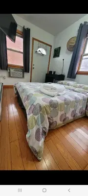 a bedroom with a bed on a wooden floor at New York in Woodside