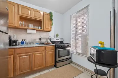 a kitchen with wooden cabinets and a stove at 1BR Apt Walk to Central Park and Columbia University in New York
