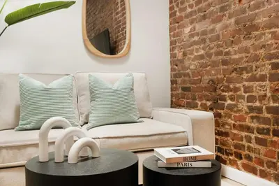 a living room with a couch and a brick wall at 153-5A Charming 2BR LES W D in New York