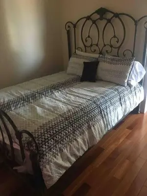 a bed with a metal headboard and pillows on it at Lovely one bedroom with free parking in Schenectady