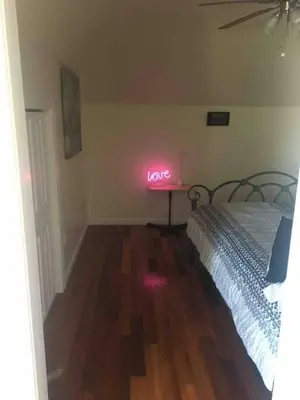 a room with a bed with a neon sign that says love at Lovely one bedroom with free parking in Schenectady