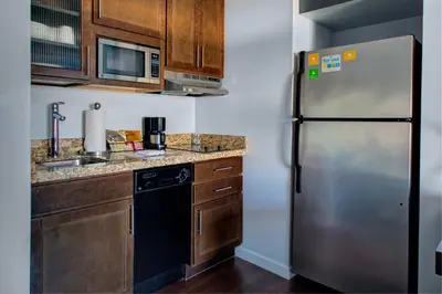 a kitchen with a stainless steel refrigerator and wooden cabinets at HYATT House Shelton in Shelton