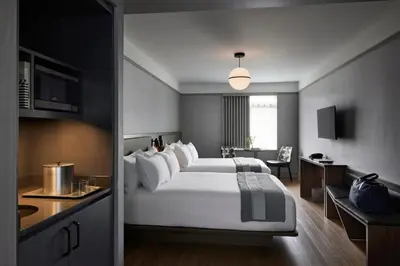 a hotel room with a large bed and a kitchen at The Melrose Hotel in Bronx