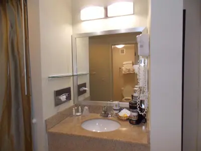 a bathroom with a sink and a mirror at Best Western Springfield West Inn in West Springfield