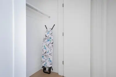 a dress hanging in a closet with white cabinets at Chelsea 1br w doorman lounge nr food hall NYC-1196 in New York
