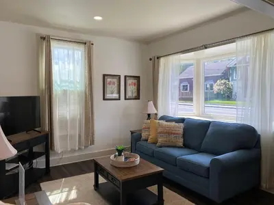 a living room with a blue couch and a tv at Water Street Apartments in Williamstown