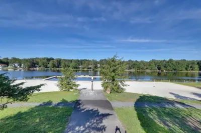 an empty park with a lake in the background at Fire Pit, Pool and Beach Access Tobyhanna Home! in Tobyhanna