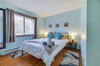 a bedroom with a bed with blue walls and a window at Fire Pit, Pool and Beach Access Tobyhanna Home! in Tobyhanna