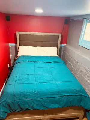 a bed in a room with a red wall at Single Room with Bathroom in Irvington