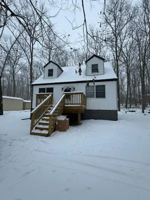 a house with a deck in the snow at The Flying Dutchman Cottage in amenities filled Masthope community Ski Big Bear in Lackawaxen