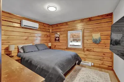 a bedroom with a bed in a room with wooden walls at Cabin in Long Pond Gameroom Pool Table in Long Pond