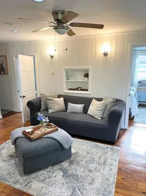 a living room with a blue couch and a table at Catskills Quaint Cottage with Peloton Minutes from Hiking in Mount Tremper
