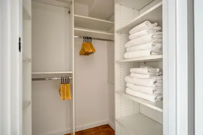 a walk in closet with white towels on shelves at Blueground UES gym balcony nr central park NYC-1404 in New York