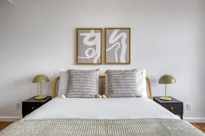a bedroom with a large bed with two lamps at Blueground UES gym balcony nr central park NYC-1404 in New York