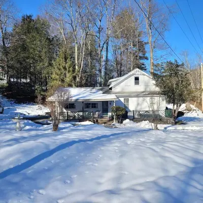 a white house with snow on the ground at Panther Mountain Lodge in Phoenicia