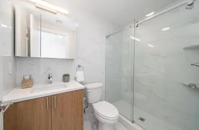 a bathroom with a toilet and a glass shower at Cozy apt with great city view in Union City