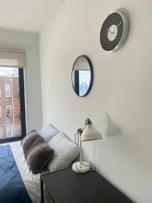 a living room with a couch and a clock on the wall at Cozy apt with great city view in Union City