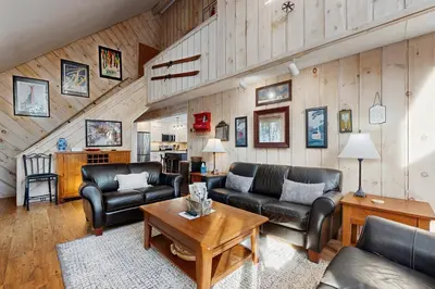 a living room with leather furniture and wooden walls at Bear's Crossing Retreat in Dover