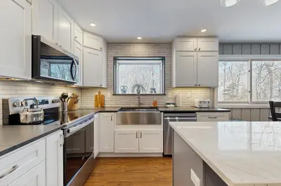 a kitchen with white cabinets and a sink at Bear's Crossing Retreat in Dover