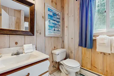 a bathroom with a toilet and a sink and a mirror at Bear's Crossing Retreat in Dover