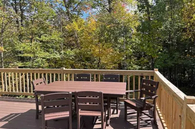 a wooden table and chairs on a deck at Bear's Crossing Retreat in Dover