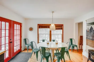 a dining room with a table and green chairs at Secluded Catskill Home with Hiking Trails On-Site! in Catskill