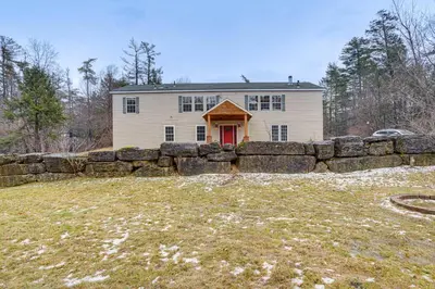 a stone retaining wall in front of a house at Secluded Catskill Home with Hiking Trails On-Site! in Catskill