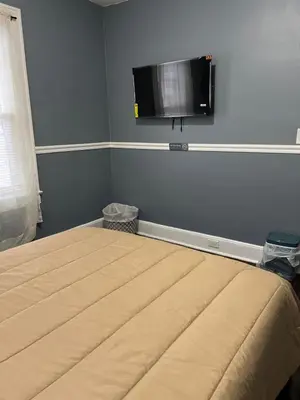 a bedroom with a bed and a flat screen tv on the wall at Two Bedrooms Home in Irvington