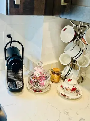 a counter with plates and a coffee maker and a cake at Eleni’s Charming Studio in North Beach