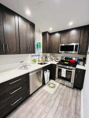 a kitchen with wooden cabinets and a stove top oven at Eleni’s Charming Studio in North Beach