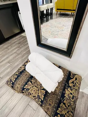 a mirror and towels on a rug in a room at Eleni’s Charming Studio in North Beach