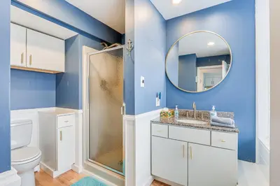 a bathroom with a toilet and a mirror at Bright Milford Beach House with Outdoor Shower in Milford