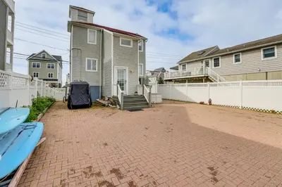 a yard with a house and a white fence at Bright Milford Beach House with Outdoor Shower in Milford