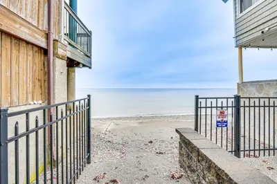 a walkway to the beach next to a building at Bright Milford Beach House with Outdoor Shower in Milford