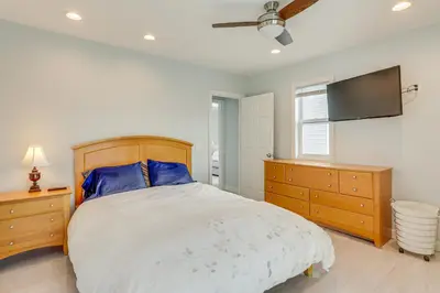 a bedroom with a bed and a flat screen tv at Bright Milford Beach House with Outdoor Shower in Milford