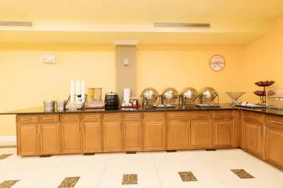 a large kitchen with wooden cabinets in a room at Romana Hotel - NYC in Queens
