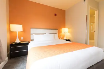 a bedroom with a large white bed with two lamps at Romana Hotel - NYC in Queens