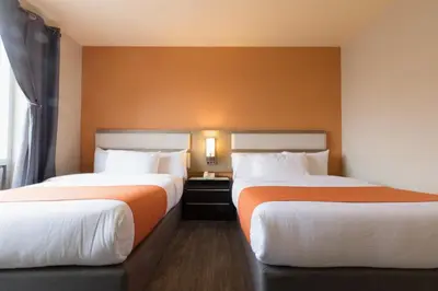 a hotel room with two beds and a window at Romana Hotel - NYC in Queens