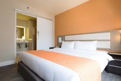 a large white bed in a hotel room at Romana Hotel - NYC in Queens