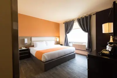 a hotel room with a bed and a window at Romana Hotel - NYC in Queens